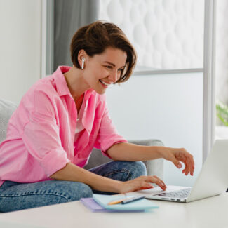 woman on sofa working online on laptop from home